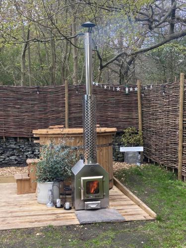 a wood fired stove in a backyard with a fence at Oak + Stars Hideaway in Holmfirth