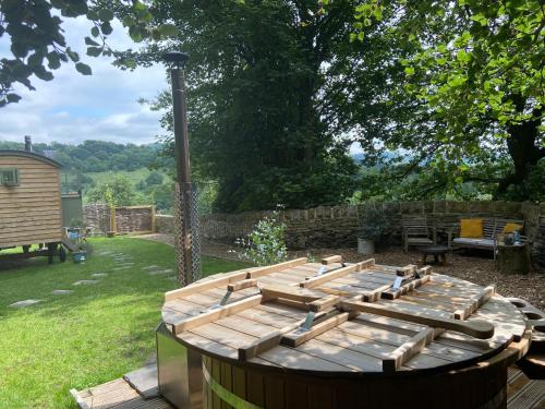 a wooden table with chairs in a yard at Oak + Stars Hideaway in Holmfirth