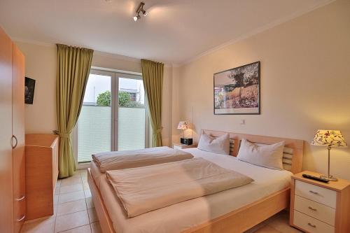 ein Schlafzimmer mit einem großen Bett und einem Fenster in der Unterkunft Moderne Strandvilla Moderne Strandvilla Appartement 2 in Timmendorfer Strand