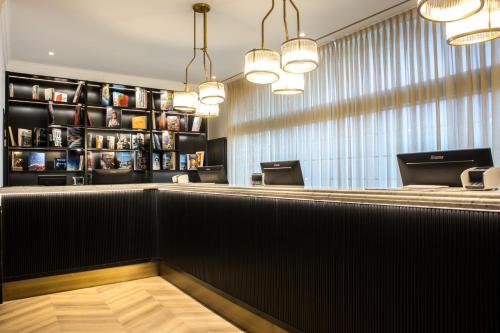 a bar in a restaurant with two chandeliers at The President Brussels Hotel in Brussels