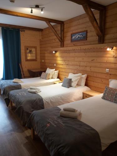 three beds in a room with wooden walls at Village Club Les Cîmes du Léman-Neaclub in Habère-Poche