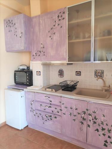 a kitchen with purple cabinets and a sink at Levantes Houses in Vathi, Ithaka