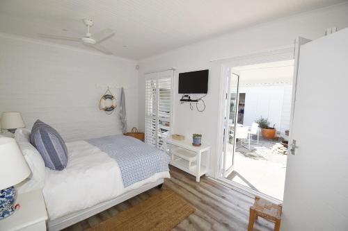 a bedroom with a bed and a sliding glass door at Tides' Song in Agulhas