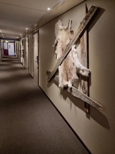 a hallway with a picture of a cross on the wall at Hotell Tjamstan Malå in Malå