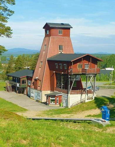 a large red building with a clock tower on it at Hotell Tjamstan Malå in Malå