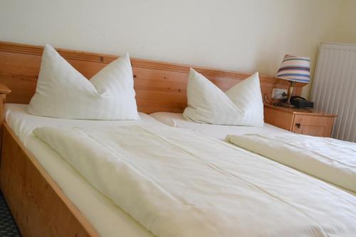 two beds with white pillows sitting next to each other at Hotel am Pfahl in Viechtach
