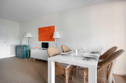 une salle à manger avec une table et des chaises blanches dans l'établissement Appartement tout confort pour 4 à 300m de la plage, à La Baule