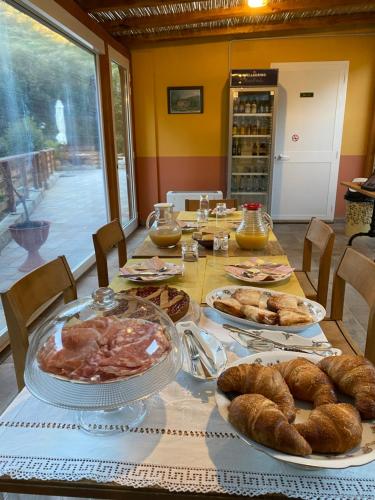 a table with bread and other food on it at B&B La Fucinaia Pet Friendly Adults only in Campiglia Marittima