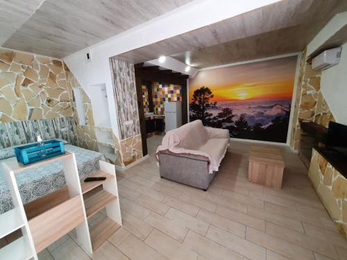a living room with a couch and a painting on the wall at Cabañas El Nogueral in Gontar