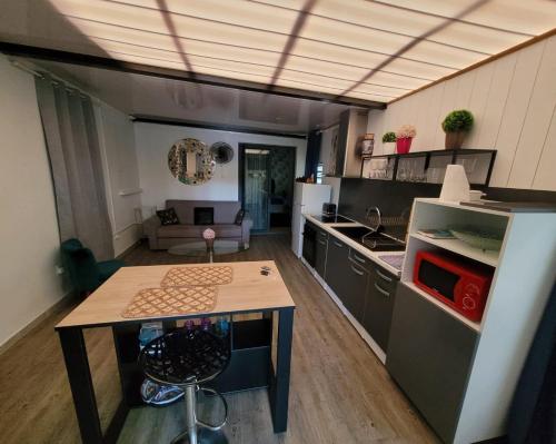 a kitchen with a table in the middle of a room at Résidence L' ALAMANDA in Saint-Philippe