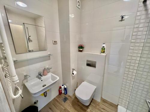 een witte badkamer met een toilet en een wastafel bij Apartmants City Love in Podgorica