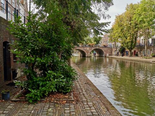 a river with a bridge in a city at Werfkelder aan de Oudegracht in Utrecht