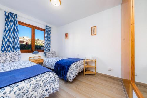a hotel room with two beds and a window at Can Nogueras in Cala Ratjada
