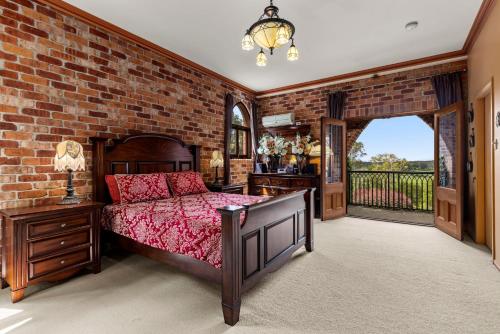 a bedroom with a bed and a brick wall at The Castle at Bonville in Bonville