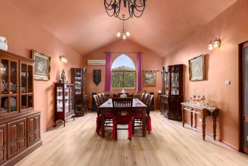 a dining room with a table and chairs and a window at The Castle at Bonville in Bonville