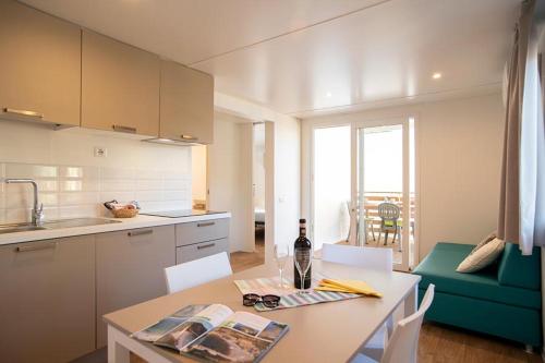 a kitchen with a table with a bottle of wine on it at Camping Europa in Capoliveri