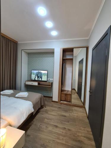 a hotel room with a bed and a mirror at Nino's Cosy Apartment in Kutaisi