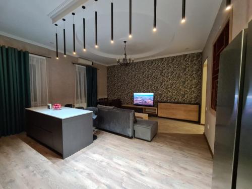 an office with a couch and a table and a tv at Nino's Cosy Apartment in Kutaisi