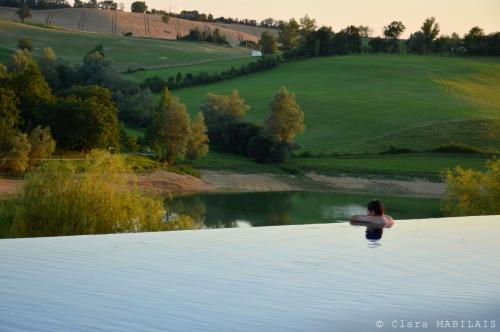 a woman standing in the water next to a lake at Résidence L'Oustal Del Carlat in Carla-Bayle