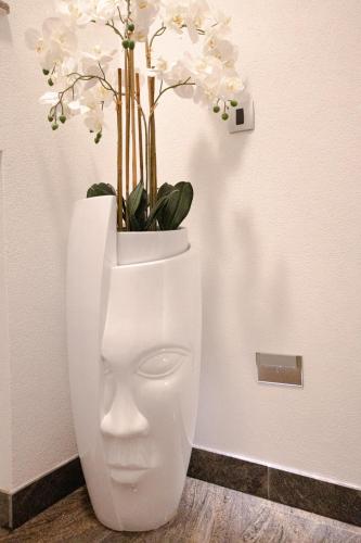 a white toilet with a vase with flowers in it at Elais Luxury Residence in Podstrana