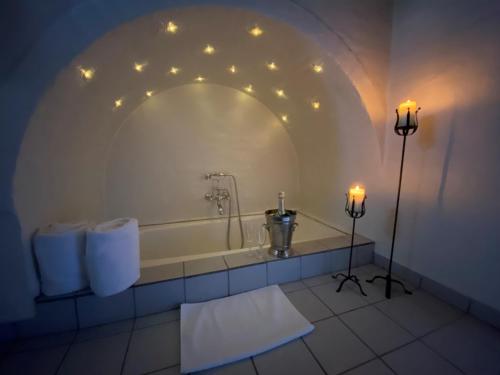 a bathroom with a bath tub with lights on the wall at Svostrup Kro in Silkeborg