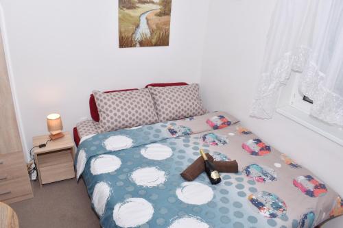 um quarto com uma cama com um edredão azul e branco em Apartman Ippon em Police