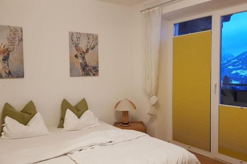 sypialnia z białym łóżkiem i oknem w obiekcie Apartment Tauernblick w mieście Ramsau am Dachstein