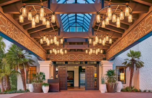 a lobby of a hotel with chandeliers and palm trees at Mar Monte Hotel, in The Unbound Collection by Hyatt in Santa Barbara