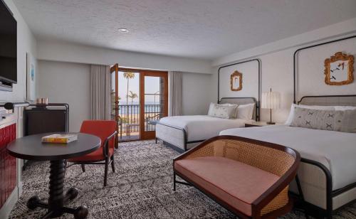 a hotel room with two beds and a desk and a table at Mar Monte Hotel, in The Unbound Collection by Hyatt in Santa Barbara