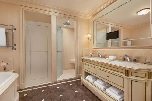 a bathroom with a sink and a shower and a tub at Shangri-La Paris in Paris