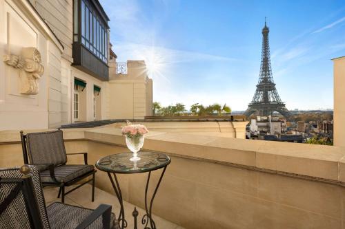 a table and chairs on a balcony with the eiffel tower at Shangri-La Paris in Paris