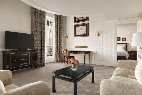 a living room with a tv and a couch and a table at Shangri-La Paris in Paris