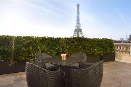 a table and chairs with the eiffel tower in the background at Shangri-La Paris in Paris