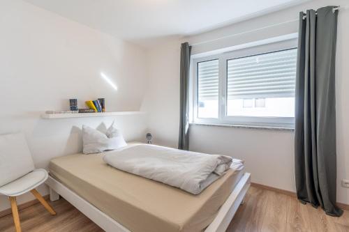 een kleine slaapkamer met een bed en een raam bij Grüntrach in Sonthofen