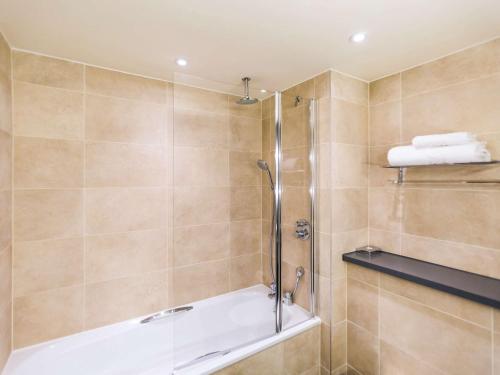 a bathroom with a shower with a tub at Mercure Dartford Brands Hatch Hotel & Spa in Ash