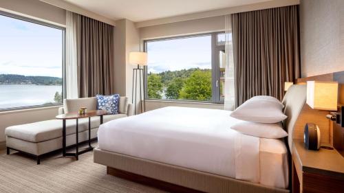 um quarto de hotel com uma cama, uma cadeira e janelas em Hyatt Regency Lake Washington at Seattle's Southport em Renton
