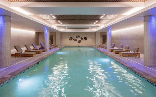 a swimming pool in a hotel lobby with chairs at Hyatt Regency Lake Washington at Seattle's Southport in Renton