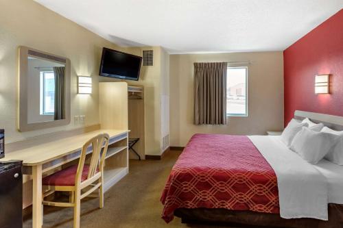 a hotel room with a bed and a desk at Econo Lodge in Belle Fourche
