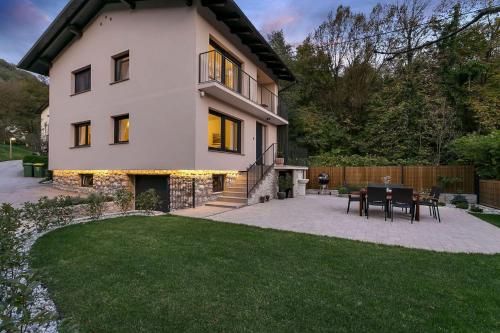 a house with a patio and a table in the yard at Angel Boutique Home - Entire premium house in Laško