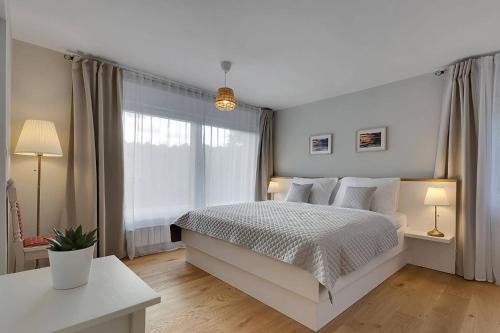 um quarto branco com uma cama e uma janela em Angel Boutique Home em Laško