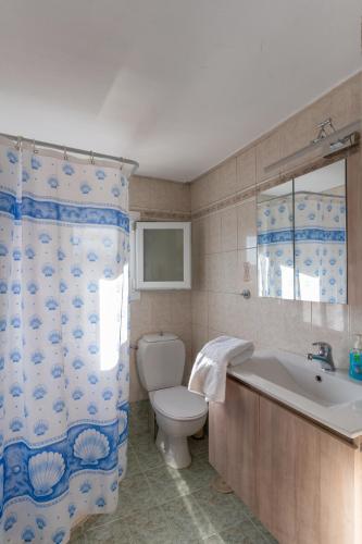 a bathroom with a toilet and a tub and a sink at Traditional House @ Chora Astypalea in Astypalaia