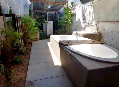 Baño con bañera en un patio en The Prawn Hatchery Pty Ltd on Amatikulu en Dokodweni
