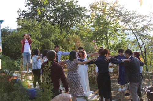 a group of people hugging each other in a garden at Toon Armeni Guest House in Dilijan