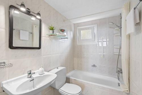 a bathroom with a sink and a toilet and a bath tub at Apartamento Cap Roig in Binibeca