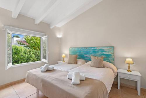 two beds in a room with a window at Apartamento Cap Roig in Binibeca
