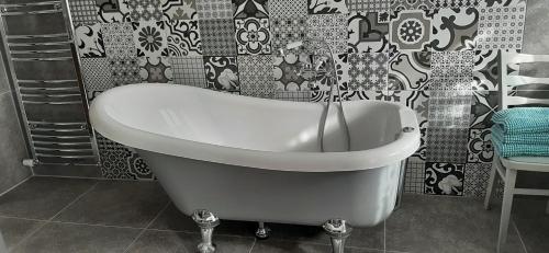 a bath tub in a bathroom with a black and white wallpaper at Babičkin Dom in Medzilaborce