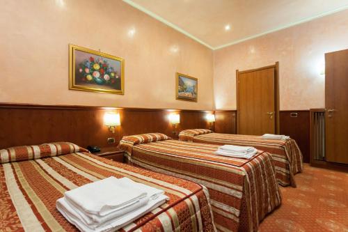 una camera d'albergo con tre letti e asciugamani di New Apartment Marghera a Milano