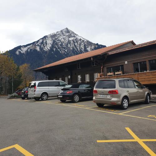 a parking lot with cars parked in front of a building at WHITE HOME IN AESCHI BEI SPIEZ in Aeschi bei Spiez