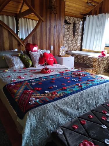 a bed with a quilt on it in a room at Pousada Rancho da Montanha in Visconde De Maua