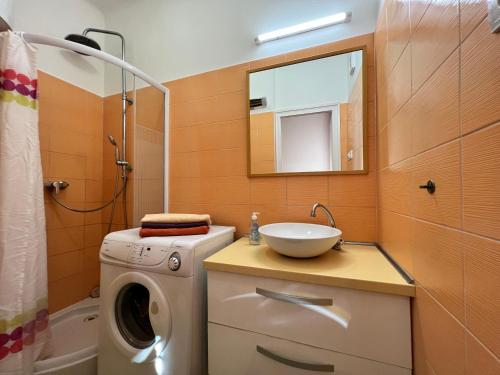 y baño con lavadora y lavamanos. en Révay Apartment en Szeged